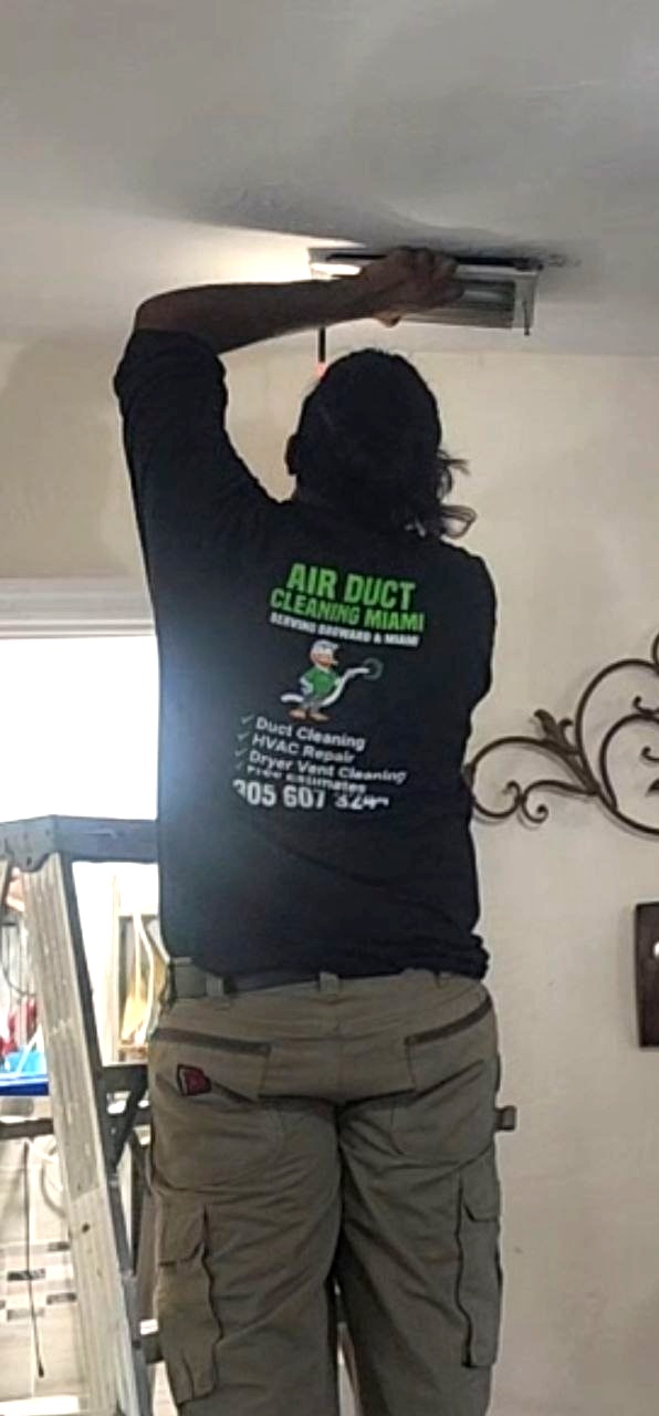Technician removing AC vent covers from ceiling for cleaning in Miramar FL
