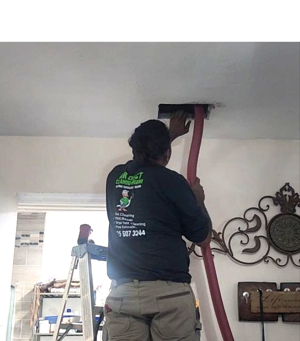 Technician using HEPA vacuum and Rotobrush to clean air ducts in Miramar